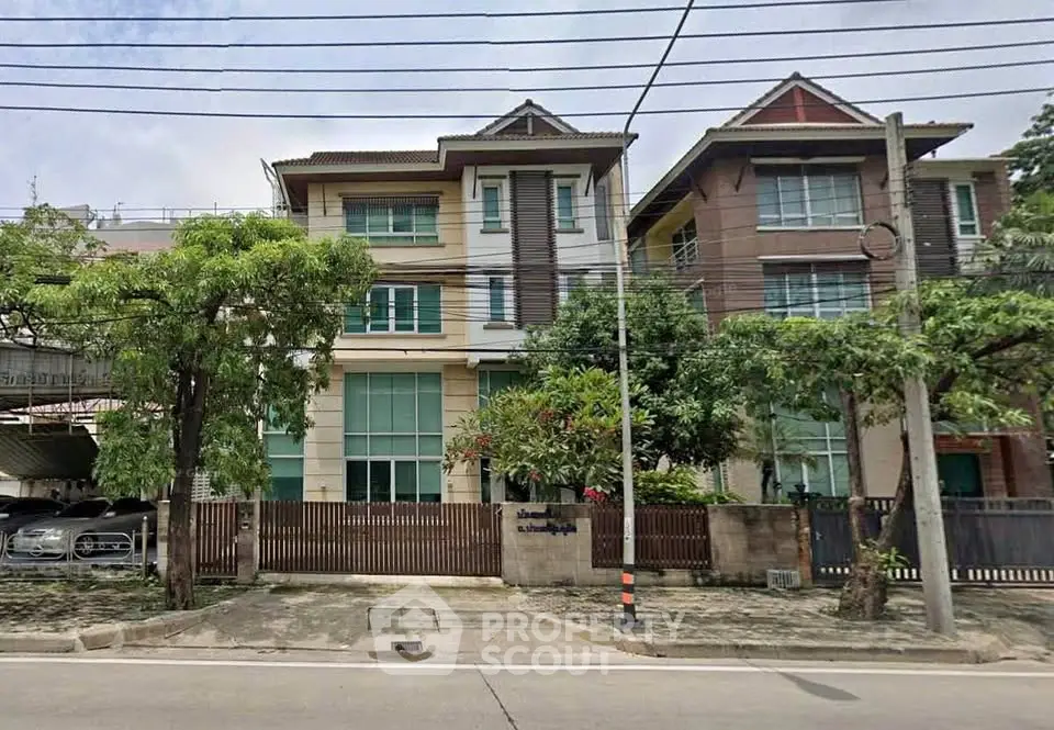 Elegant multi-story residential building with lush greenery and secure parking in a serene neighborhood.