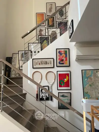 Stylish staircase with modern art and sleek railing in contemporary home