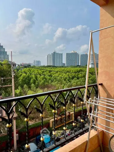 Stunning balcony view overlooking lush greenery and city skyline, perfect for urban nature lovers.