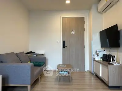 Modern living room with cozy sofa, wall-mounted TV, and stylish decor in a contemporary apartment.