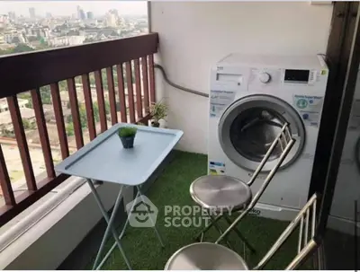 Charming balcony with city view, featuring a washing machine and cozy seating area.