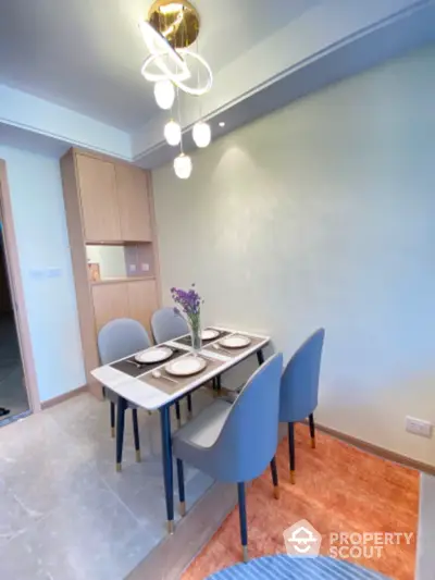 Modern dining area with elegant lighting and stylish chairs in a contemporary apartment.