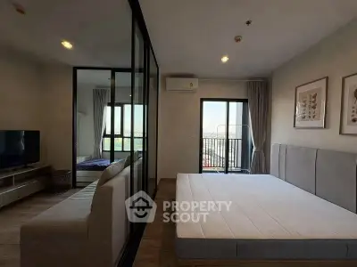 Modern bedroom with large windows and balcony access in a stylish apartment.