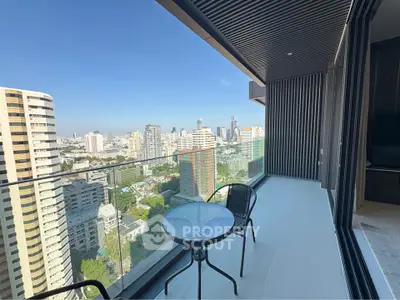 Stunning city view from modern high-rise balcony with sleek glass railing and cozy seating.
