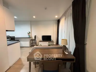 Modern living room with open kitchen and stylish decor in a cozy apartment.