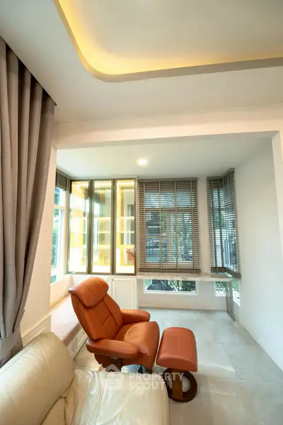 Luxurious living room with leather recliner and modern window design