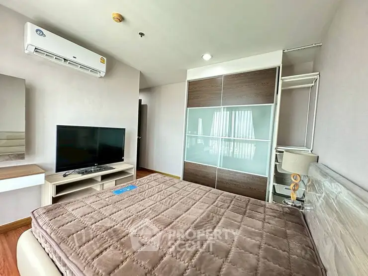 Modern bedroom with sleek furniture and air conditioning in a stylish apartment.