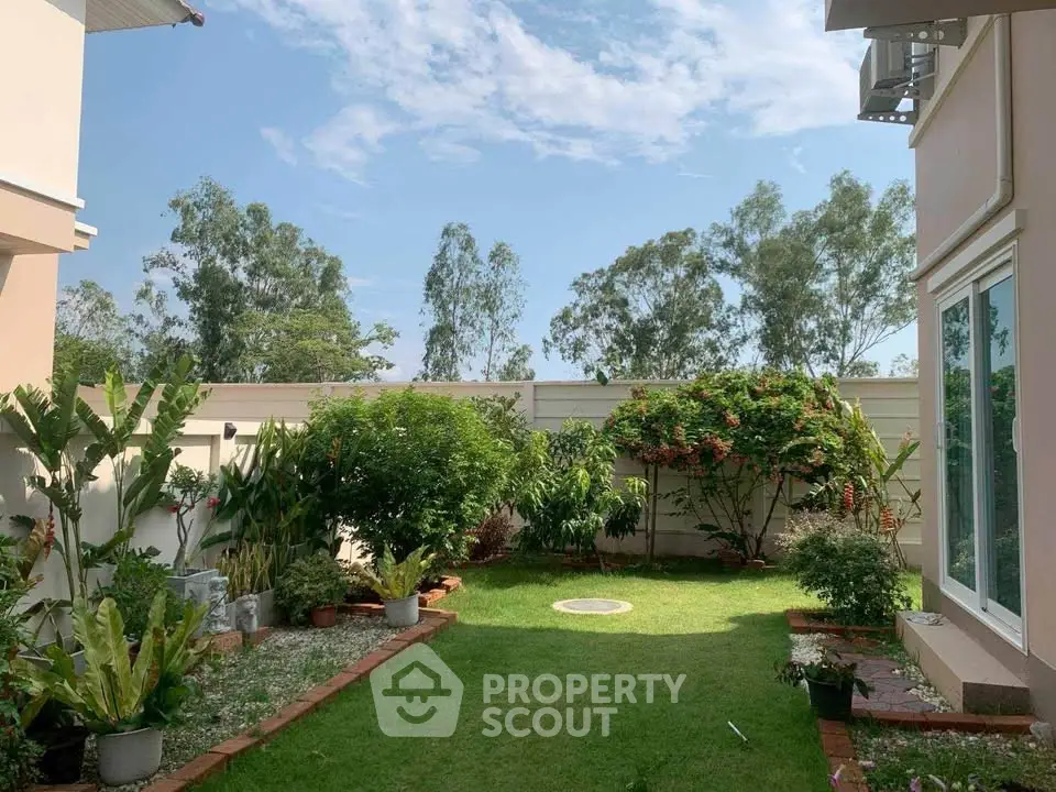 Beautiful garden with lush greenery and clear blue sky in a residential property.