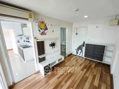 Modern living room with wooden flooring and stylish wall art in a cozy apartment.