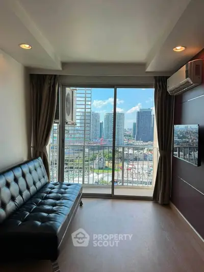 Modern living room with city view, featuring sleek black sofa and large windows for natural light.