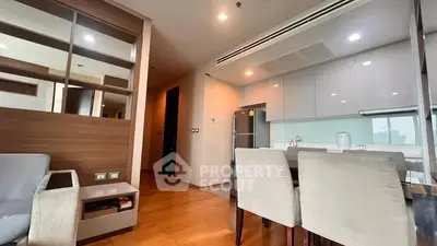 Modern open-layout kitchen and dining area with sleek design and wooden accents.