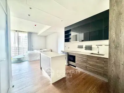 Modern open-layout kitchen and living area with sleek design and natural light.