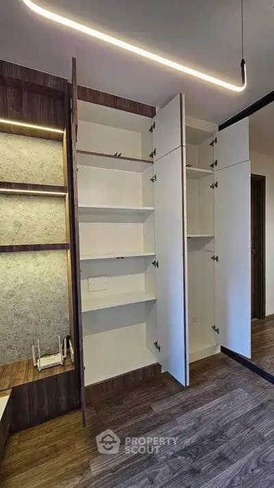 Modern interior with open storage cabinets and stylish lighting in a contemporary home.