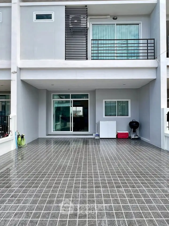 Modern townhouse exterior with tiled driveway and balcony
