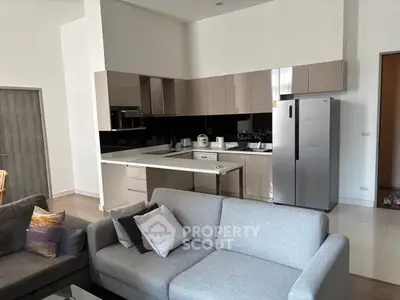 Modern open kitchen with sleek cabinetry and stainless steel appliances in a stylish living area.