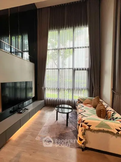 Luxurious modern living room with high ceilings and large windows, elegant decor and natural light.