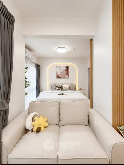 Cozy modern bedroom with stylish decor and plush sofa, perfect for relaxation and comfort.