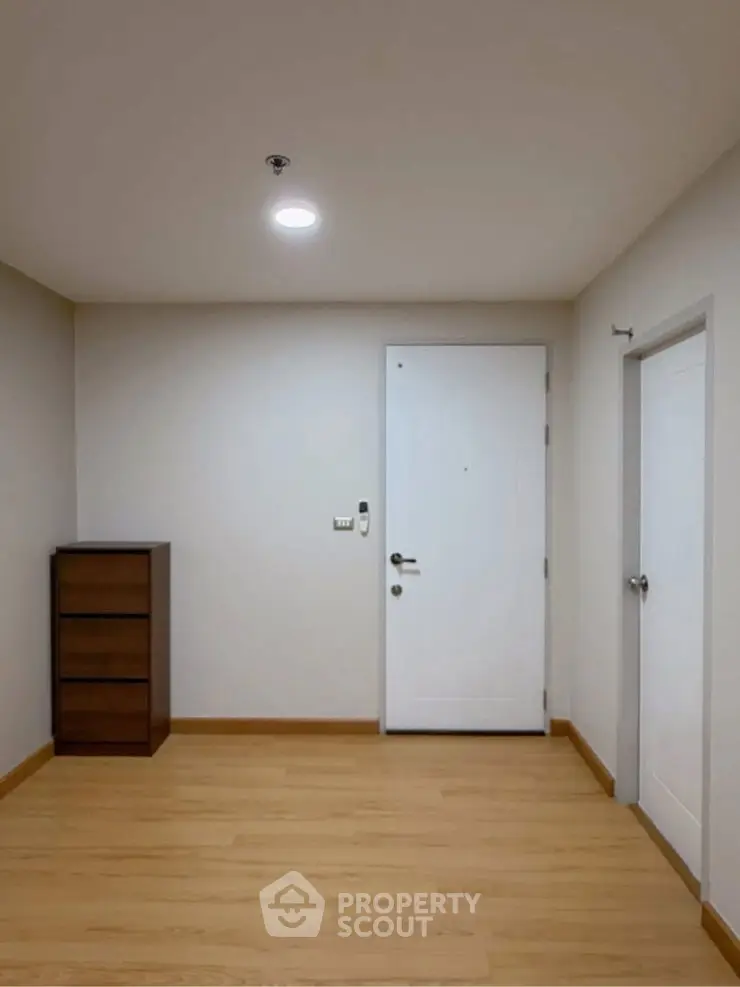 Minimalist interior with wooden flooring and white doors, perfect for modern living.