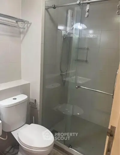 Modern bathroom with glass shower enclosure and sleek fixtures.