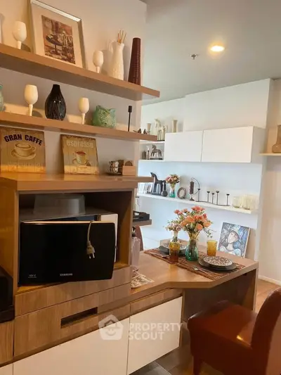 Modern kitchen with stylish decor and built-in microwave, featuring open shelving and elegant table setting.