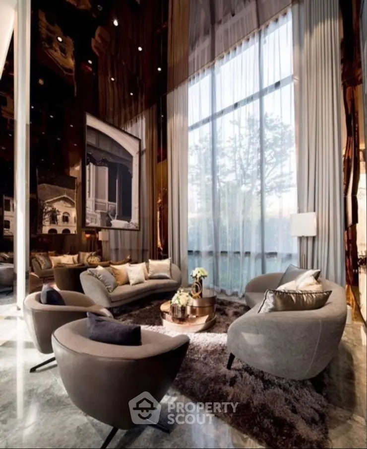Luxurious high-ceiling living room with elegant furniture and large windows.