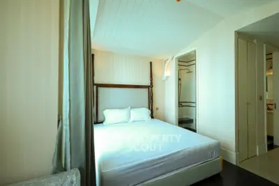 Cozy bedroom with elegant decor and ample natural light, featuring a comfortable bed and stylish furnishings.