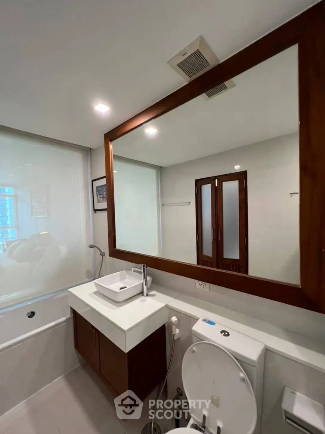 Modern bathroom with large mirror and sleek fixtures in a contemporary home.