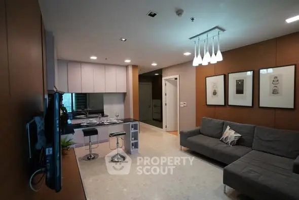 Modern living room with open kitchen, stylish decor, and cozy seating area in a contemporary apartment.