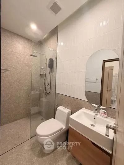 Modern bathroom with glass shower, sleek fixtures, and elegant tile design.