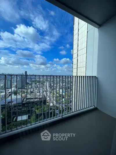 Stunning high-rise balcony with panoramic city view and blue sky.