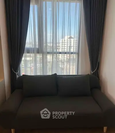 Cozy living room with dark sofa and large window view