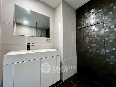 Modern bathroom with sleek vanity and stylish tiled shower area