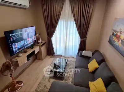 Cozy living room with modern decor, large TV, and comfortable seating.