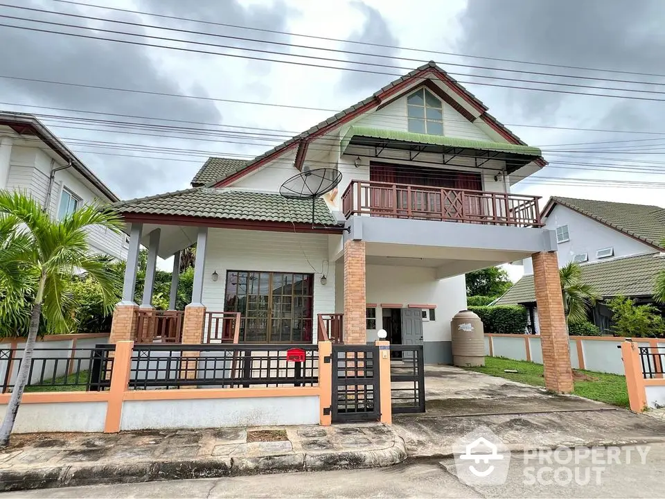 Charming two-story house with balcony and driveway in a serene neighborhood.