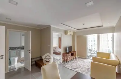 Modern living room with open layout and city view, featuring cozy seating and TV area.