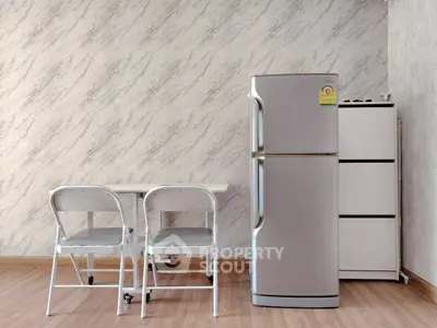 Modern kitchen corner with fridge and dining set on wooden floor