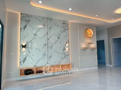 Modern living room with marble accent wall and ambient lighting, showcasing elegant interior design.