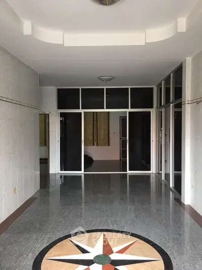 Spacious living room with glossy tiled floor and large windows