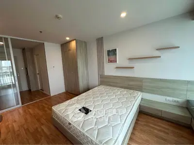 Spacious bedroom with modern design and wooden flooring in a stylish apartment.