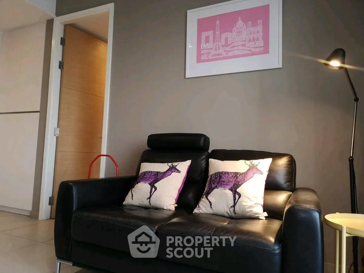 Modern living room with stylish black leather sofa and artistic decor