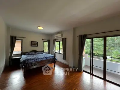 Spacious bedroom with balcony and natural light in modern home