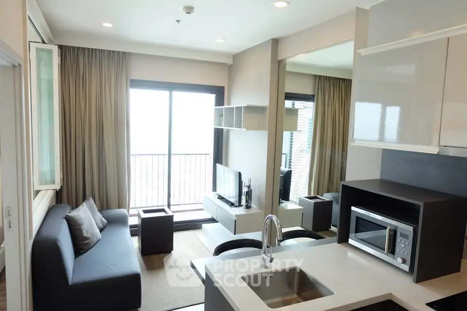 Modern living room with open kitchen and balcony view in stylish apartment