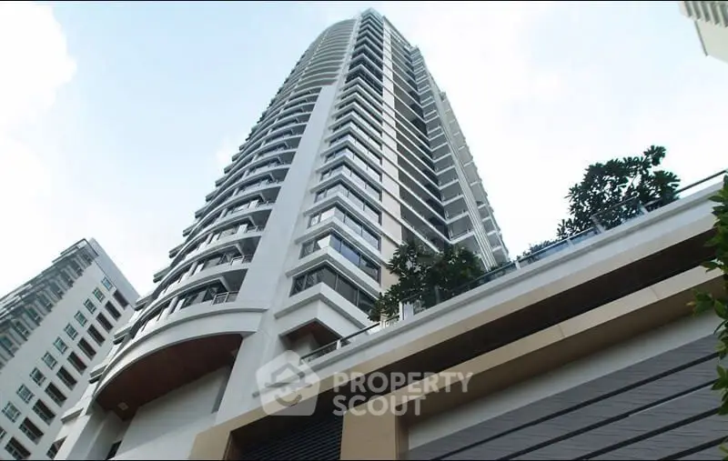 Stunning modern high-rise building with sleek architectural design and lush greenery.