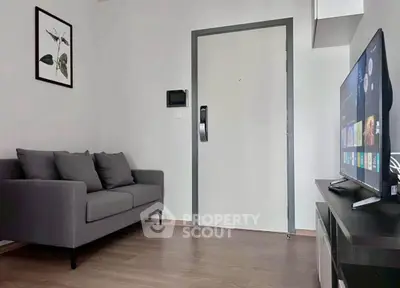 Modern living room with sleek gray sofa and wall-mounted TV, perfect for cozy relaxation.