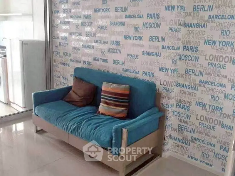 Stylish living room with modern blue sofa and city-themed wallpaper, perfect for urban living.