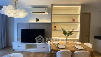 Modern living room with stylish lighting, TV unit, and dining area, perfect for contemporary living.