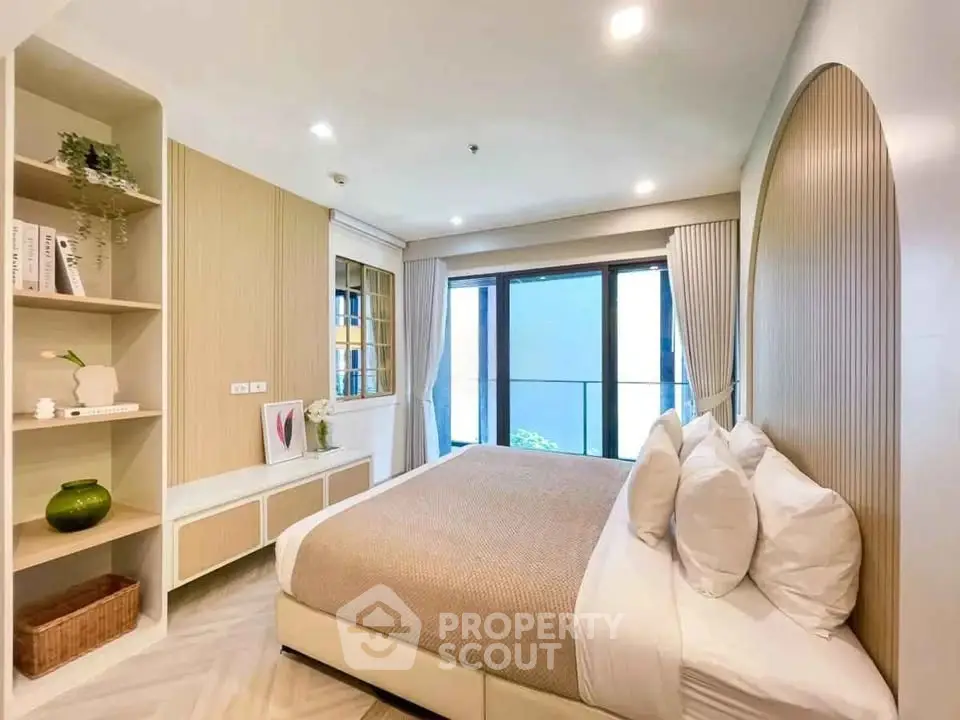 Modern bedroom with elegant decor and large window offering natural light