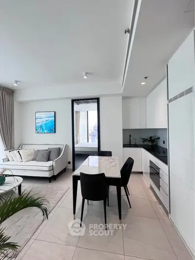 Modern open-plan living room and kitchen with sleek design and elegant furnishings.