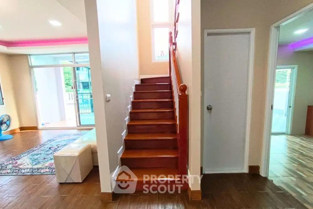 Spacious interior with wooden staircase and modern decor, perfect for family living.