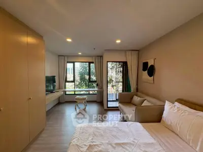 Spacious bedroom with cozy seating and natural light in modern apartment